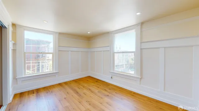 a view of empty room with wooden floor
