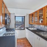 a kitchen with a sink and a stove next to a large window