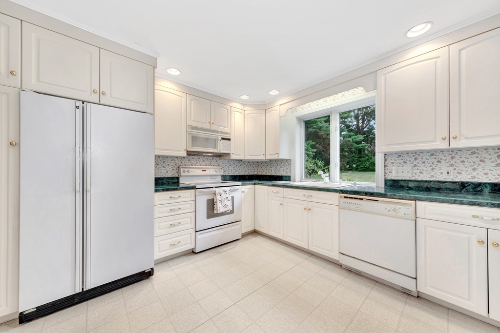 21 Gleason Road Lexington, MA 02420 - Photo 23 of 42 a kitchen with granite countertop white cabinets and white appliances
