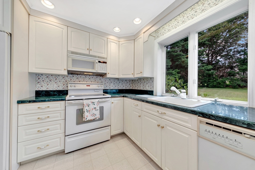 21 Gleason Road Lexington, MA 02420 - Photo 25 of 42 a kitchen with granite countertop white cabinets and white appliances