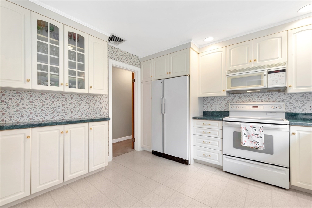21 Gleason Road Lexington, MA 02420 - Photo 26 of 42 a kitchen with granite countertop white cabinets and white appliances