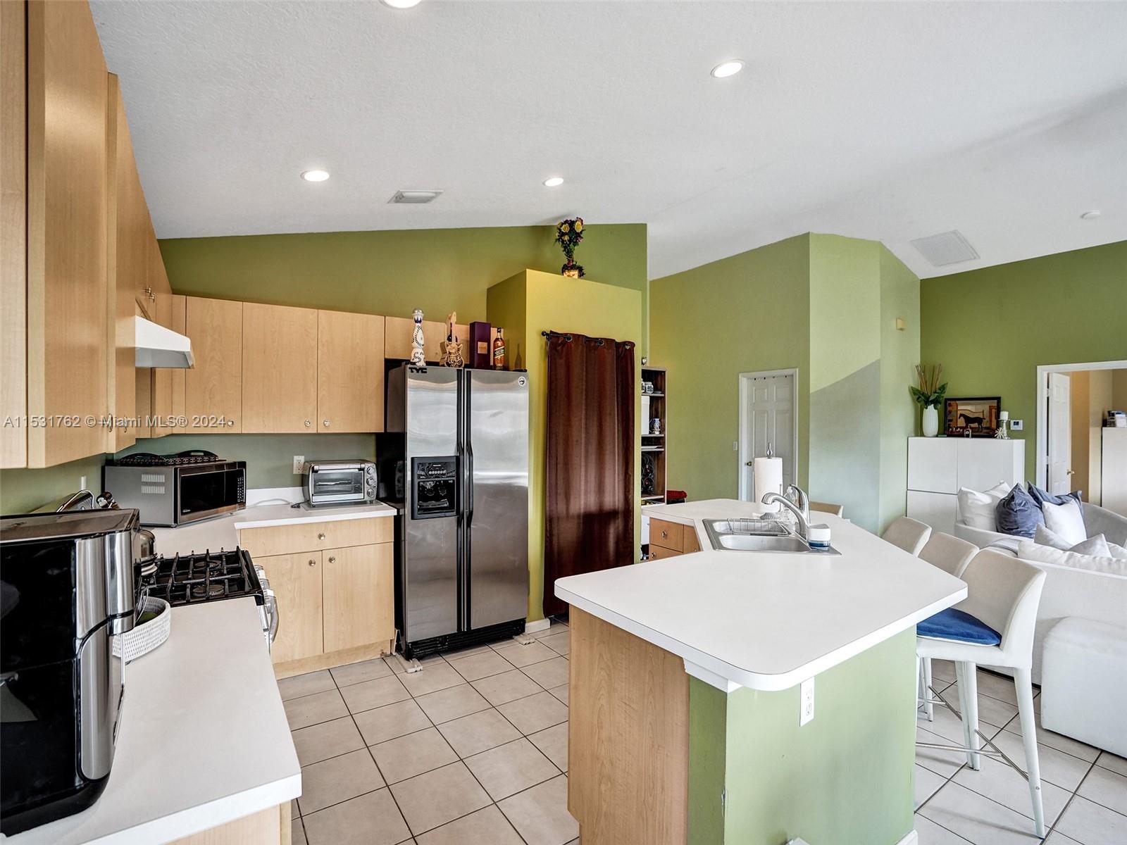 Greenacres Greenacres, FL 33413 - Photo 13 of 61 a kitchen with a sink a refrigerator and chairs