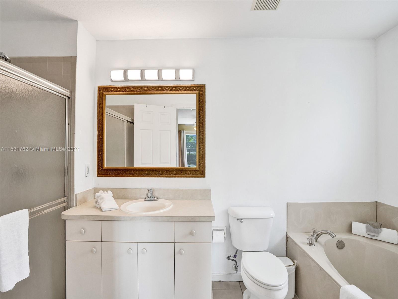 Greenacres Greenacres, FL 33413 - Photo 26 of 61 a bathroom with a bathtub shower sink mirror and toilet