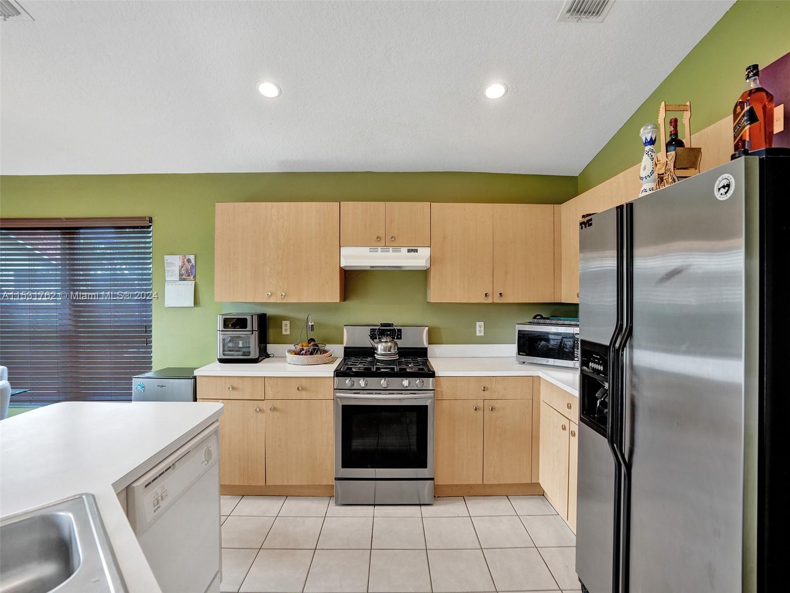 Greenacres Greenacres, FL 33413 - Photo 9 of 61 a kitchen with a stove a refrigerator and a sink