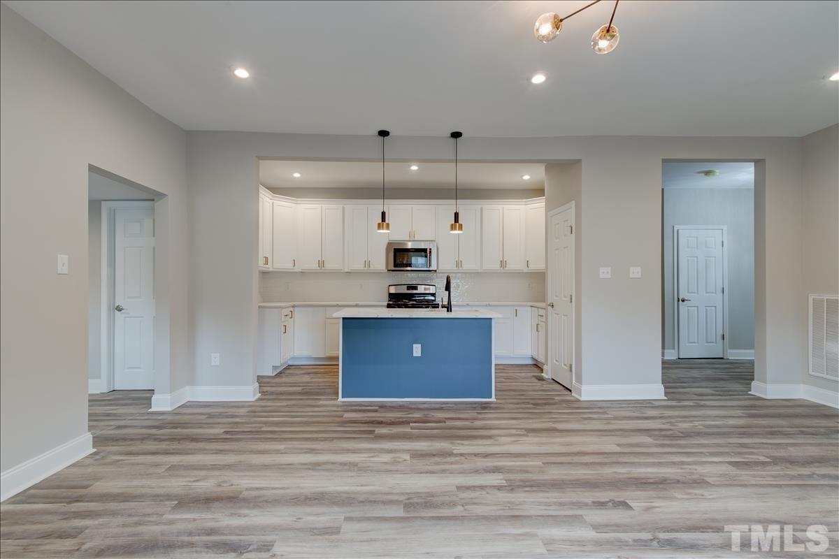 1801 East Garner Road Raleigh, NC 27610 - Photo 8 of 15 a room with kitchen island a sink stainless steel appliances and cabinets