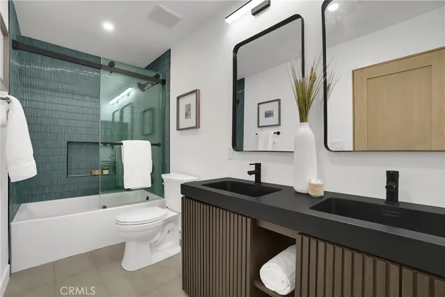 a bathroom with a granite countertop sink mirror vanity and toilet