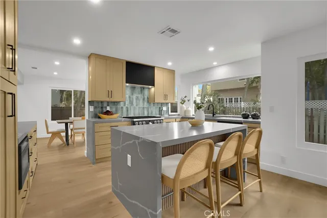 a kitchen with granite countertop a sink stove and cabinets