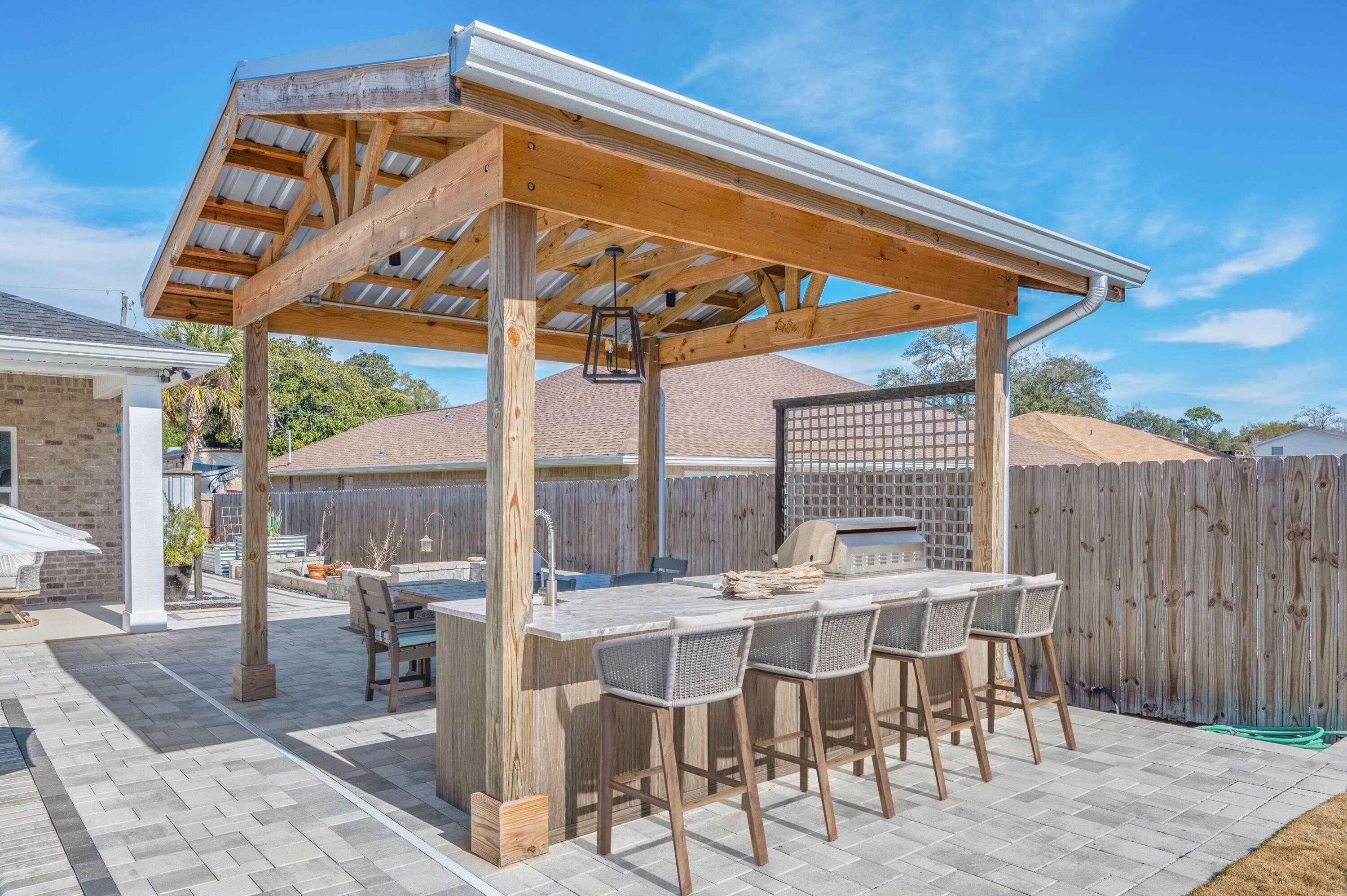 8 Maple Avenue Shalimar, FL 32579 - Photo 6 of 71 a view of a patio with table and chairs with wooden floor and fence