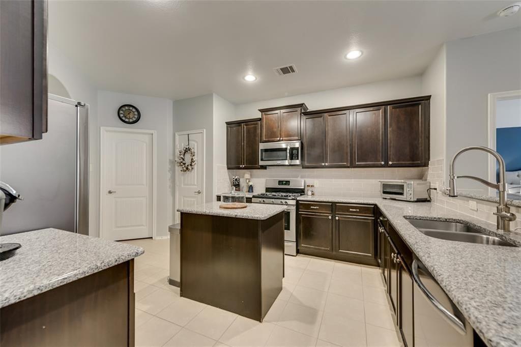 3406 Van Zandt Road Melissa, TX 75454 - Photo 4 of 6 a kitchen with stainless steel appliances granite countertop a sink stove and refrigerator