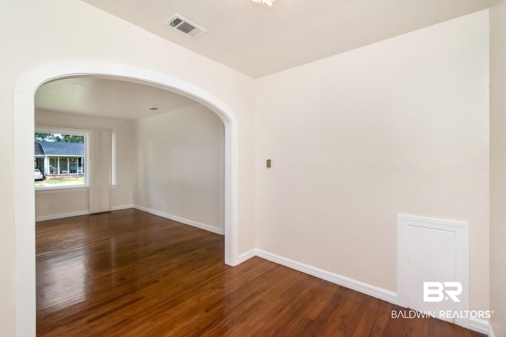 1477 Fairfield Street Mobile, AL 36606 - Photo 14 of 34 Empty room with arched walkways and dark wood-style flooring