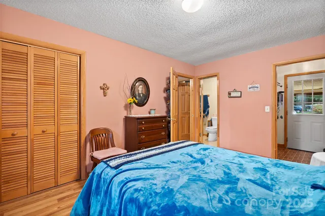 a bedroom with a bed and a dresser with wooden floor