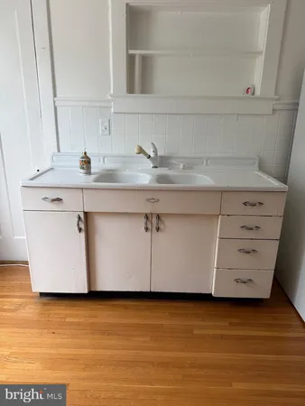 a view with granite countertop a sink a stove and cabinets