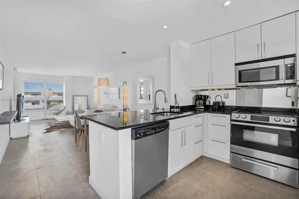 a kitchen with stainless steel appliances kitchen island granite countertop a stove and a sink