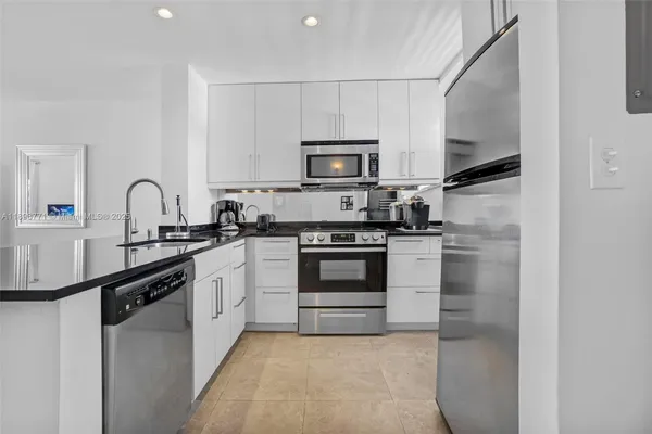 a kitchen with cabinets stainless steel appliances and a sink