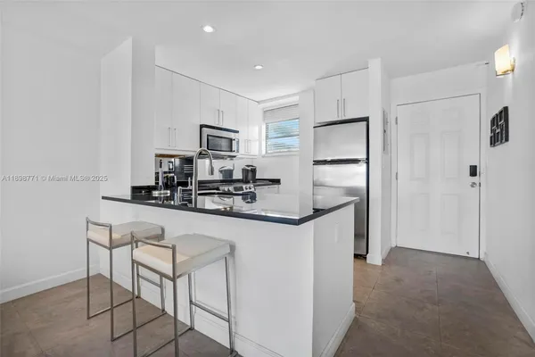 a kitchen with kitchen island a refrigerator stove and microwave