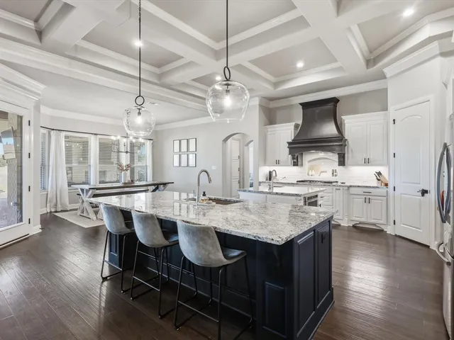 a kitchen with a stove a chandelier and wooden floor
