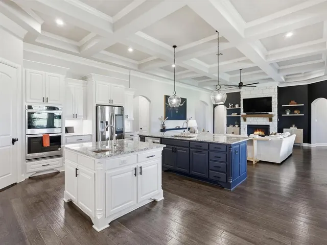 a large white kitchen with stainless steel appliances