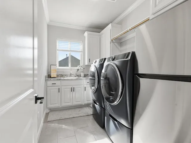 a utility room with sink dryer and washer