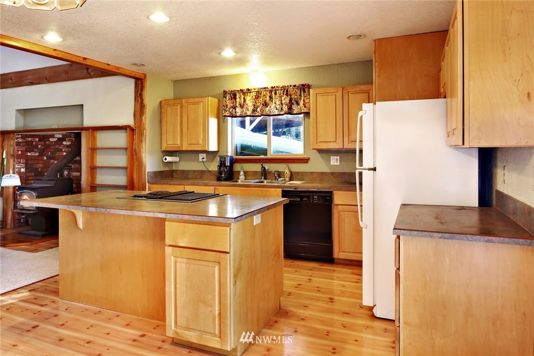 2587 Birch Bay Lynden Road Custer, WA 98240 - Photo 17 of 39 a kitchen with stainless steel appliances granite countertop a sink a stove a refrigerator a washer and dryer with wooden floors