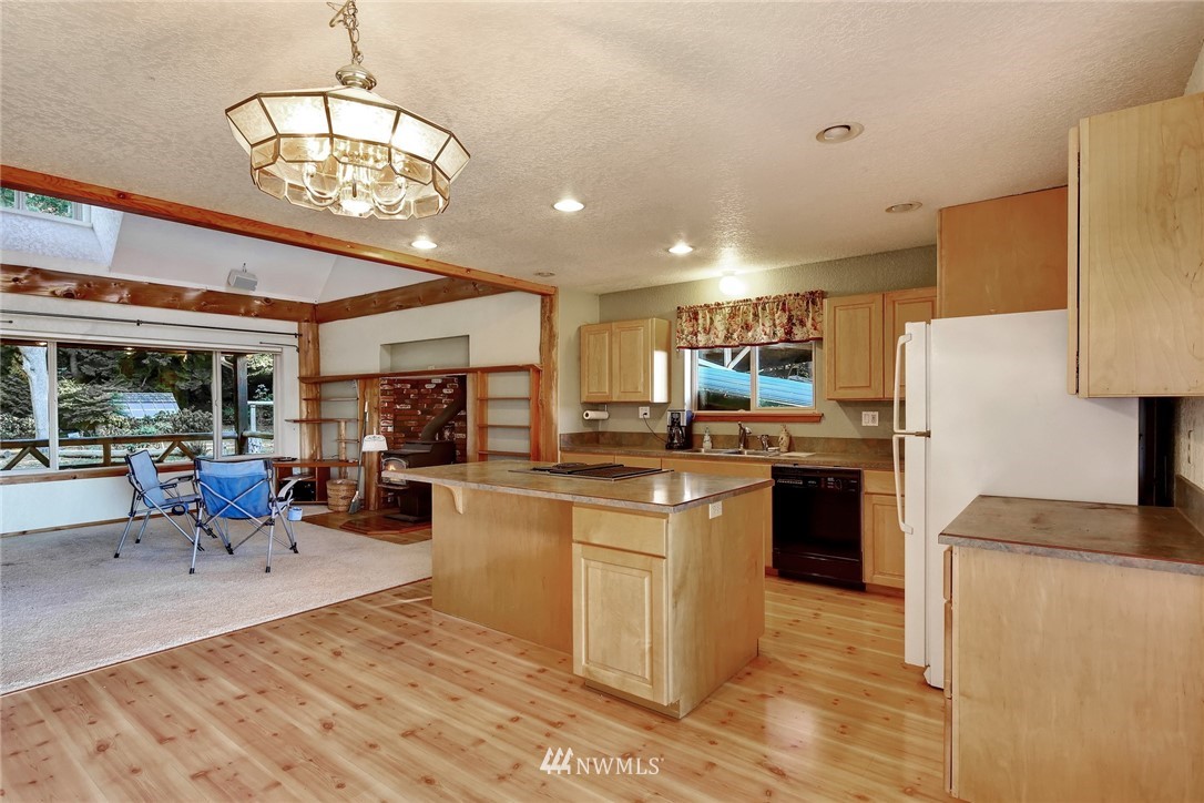 2587 Birch Bay Lynden Road Custer, WA 98240 - Photo 19 of 39 a kitchen with stainless steel appliances kitchen island granite countertop a refrigerator a stove top oven a sink dishwasher and couches with wooden floor