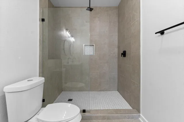 a bathroom with a toilet and a shower