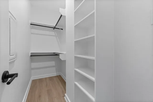 a view of walk in closet with empty racks