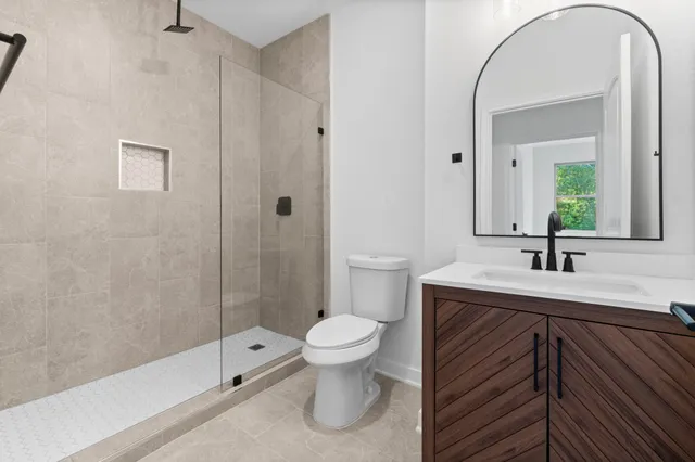 a bathroom with a sink a toilet and a large mirror