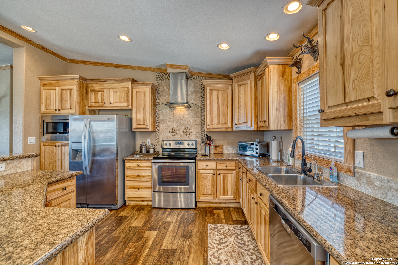 2242 Patterson Creek Road Leakey, TX 78873 - Photo 48 of 57 a kitchen with stainless steel appliances granite countertop a refrigerator a stove top oven and sink