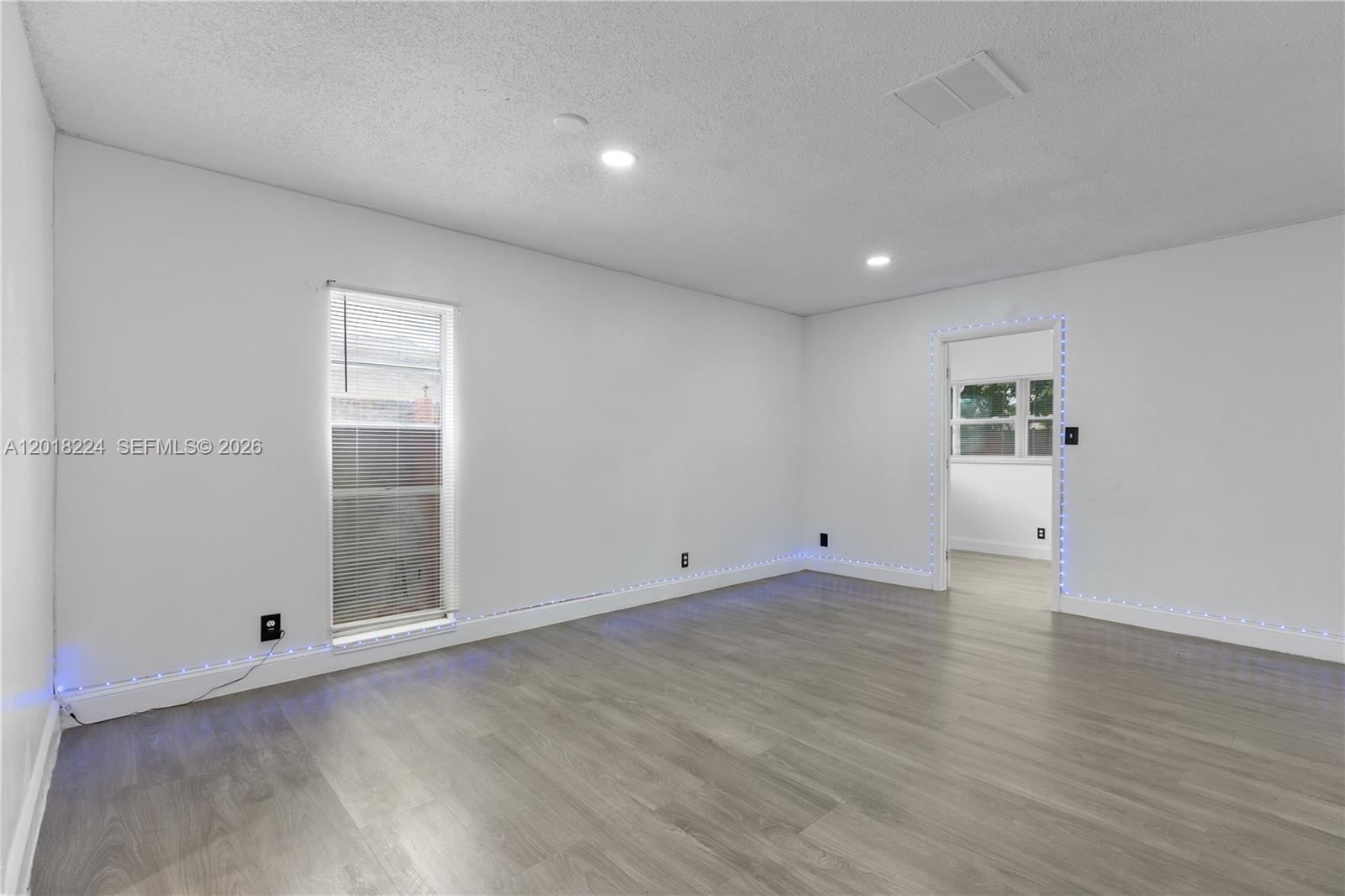 7958 Southwest 6th Street Pompano Beach, FL 33068 - Photo 6 of 57 an empty room with wooden floor and windows