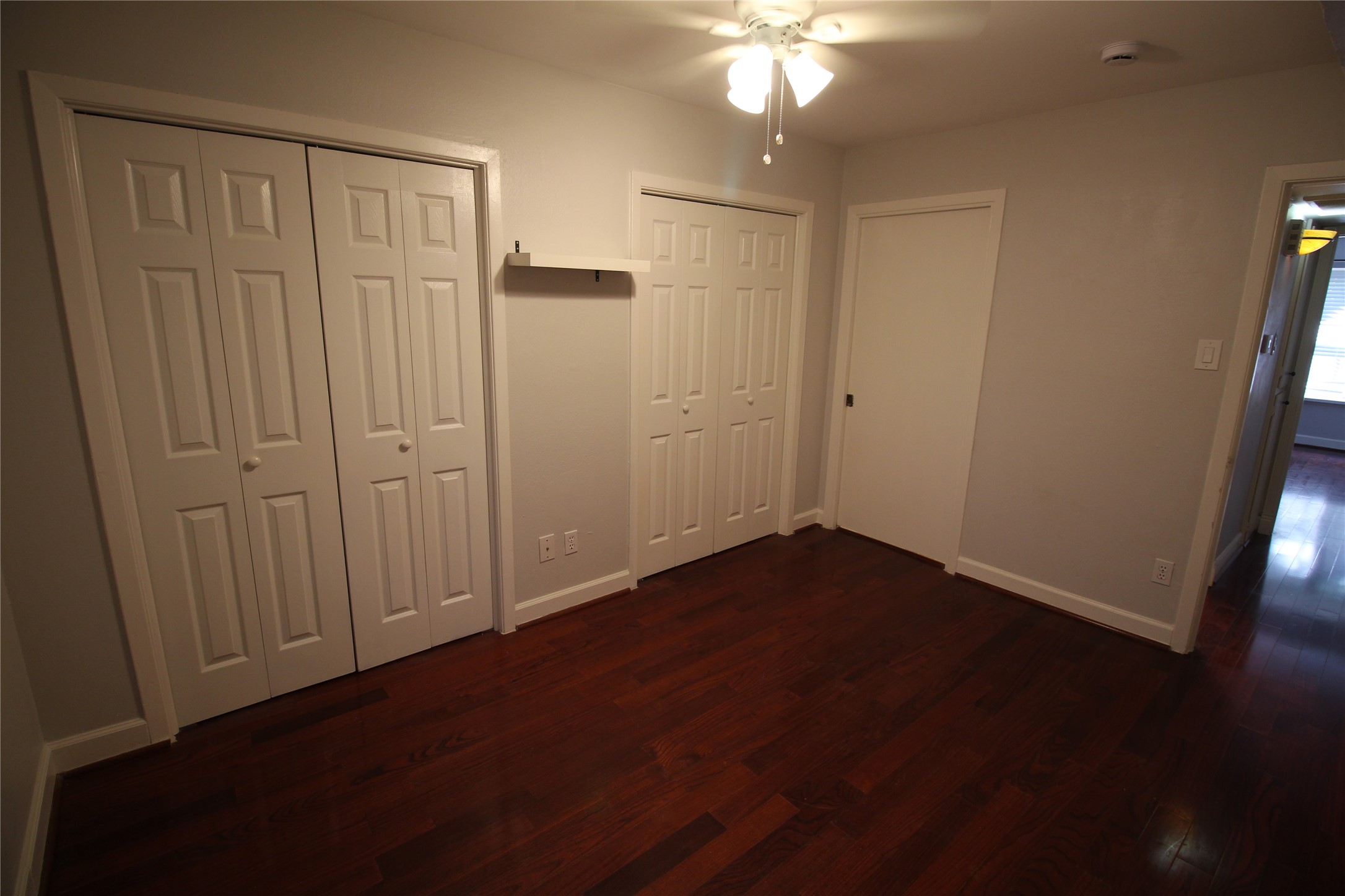 8277 Kingsbrook Road, Unit 255 Houston, TX 77024 - Photo 19 of 27 an empty room with wooden floor fan and windows