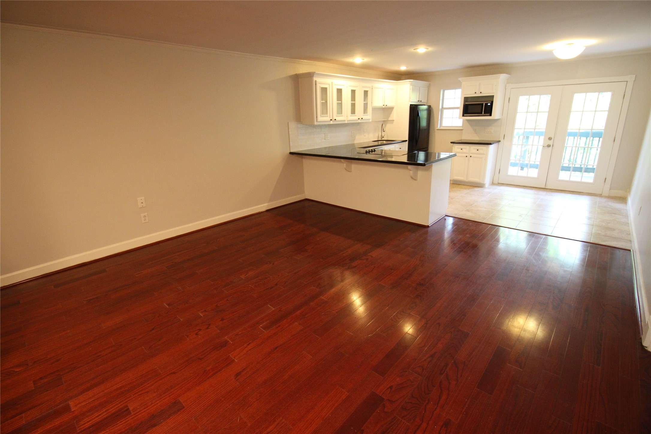 8277 Kingsbrook Road, Unit 255 Houston, TX 77024 - Photo 6 of 27 a kitchen with granite countertop wooden floors and wide window