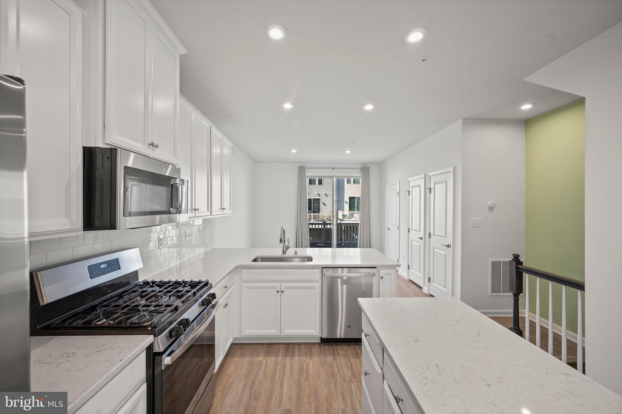 3769 Cedar Mountain Way Hanover, MD 21076 - Photo 7 of 52 a kitchen with stainless steel appliances sink stove microwave and cabinets