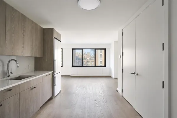 a view of a kitchen with a sink and dishwasher with wooden floor