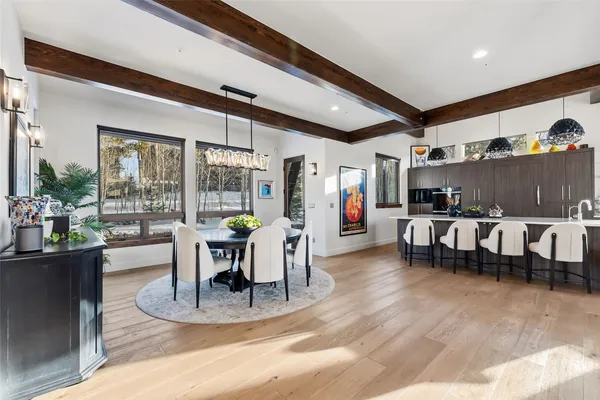 a dining room with furniture potted plants and wooden floor