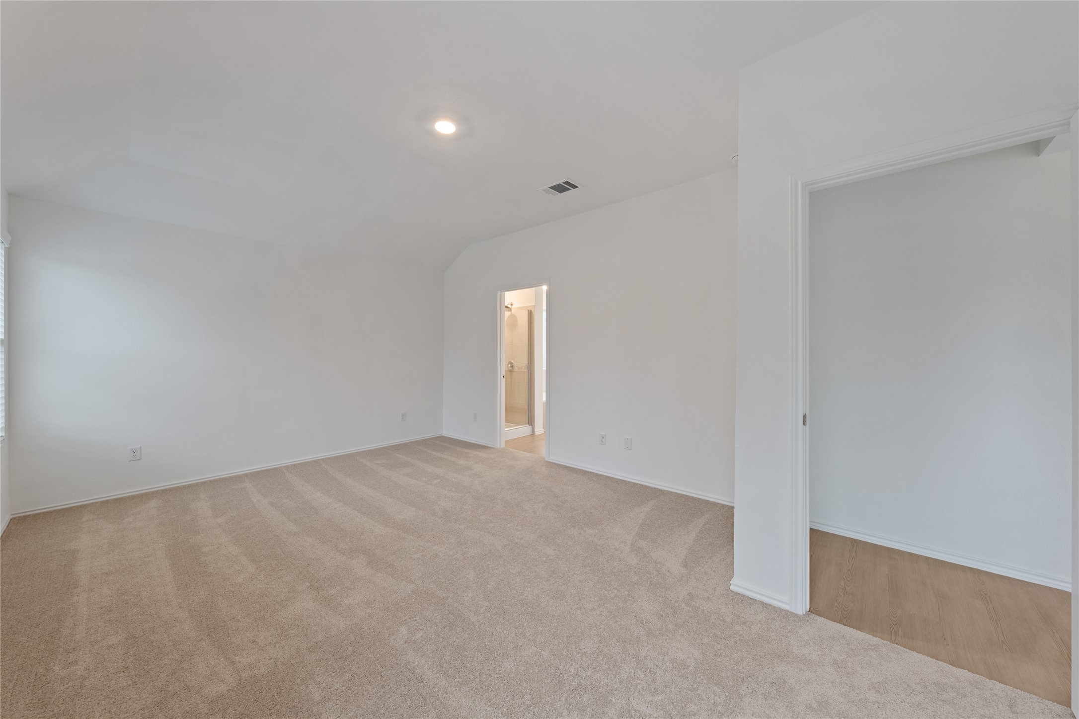 115 Parsons Kyle, TX 78640 - Photo 6 of 18 A spacious carpeted room with a view into an adjacent bathroom, offering ample living flexibility.