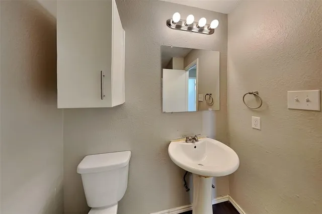 a bathroom with a toilet a sink and mirror