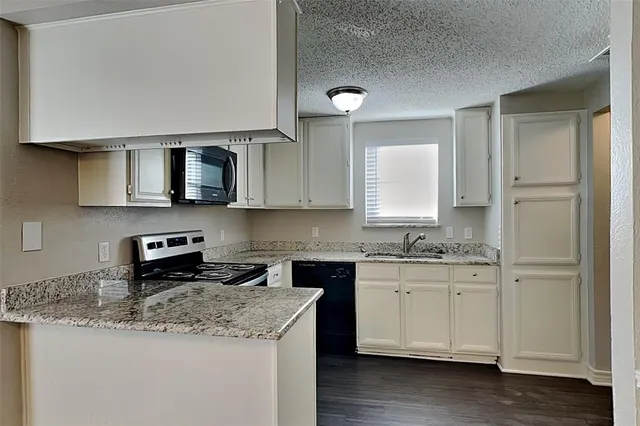 a kitchen with stainless steel appliances granite countertop a sink stove and microwave