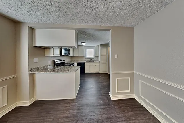 a kitchen with a refrigerator and a stove top oven