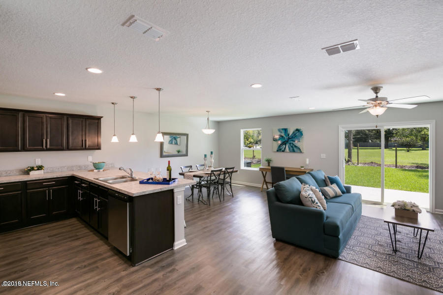 4114 Barnes Road South Jacksonville, FL 32207 - Photo 8 of 10 a living room with stainless steel appliances kitchen island granite countertop wooden floor a dining table and chairs