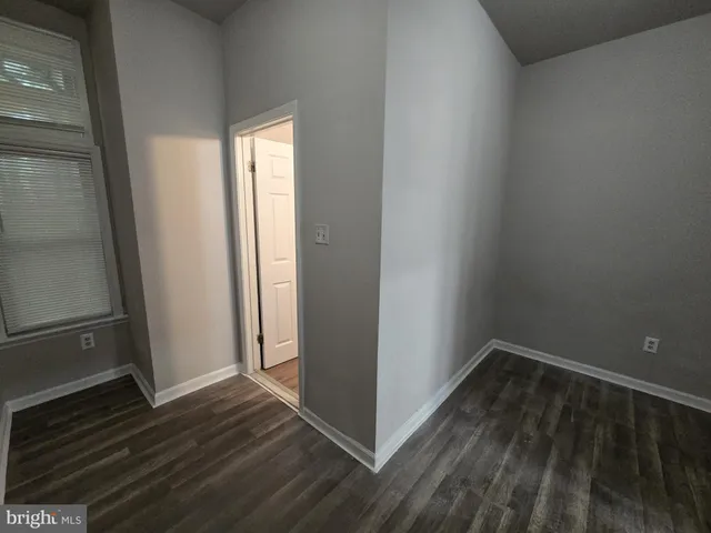 a view of a room with wooden floor and a window