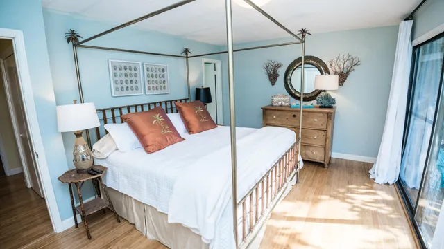 a bedroom with a bed a mirror and paintings on the wall