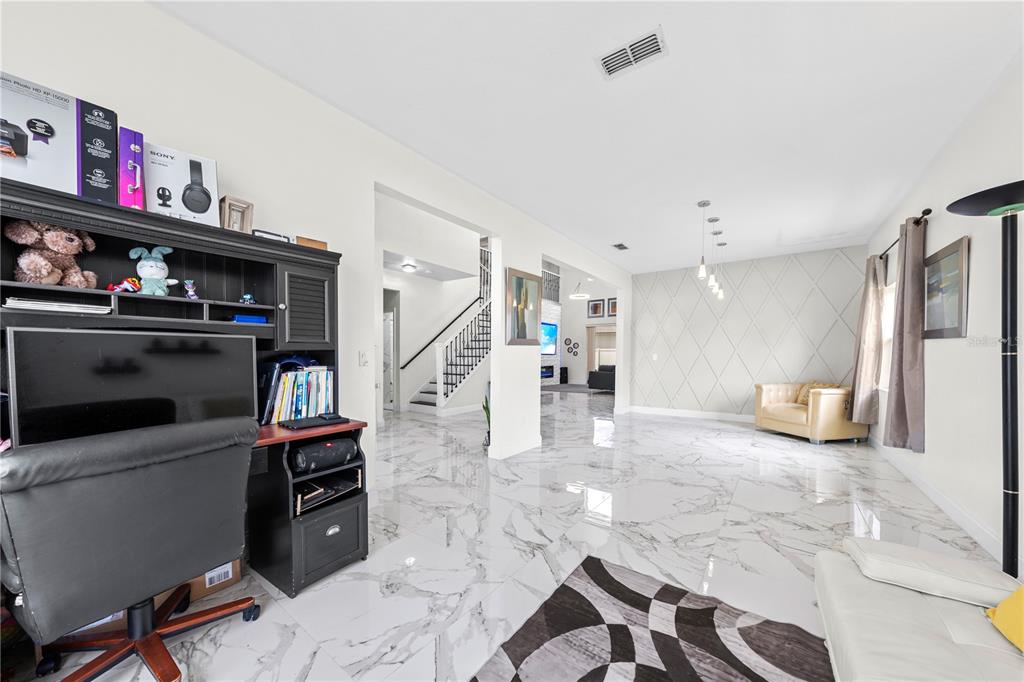 4301 Presidio Way Kissimmee, FL 34746 - Photo 11 of 50 a living room with furniture a flat screen tv and a book shelf