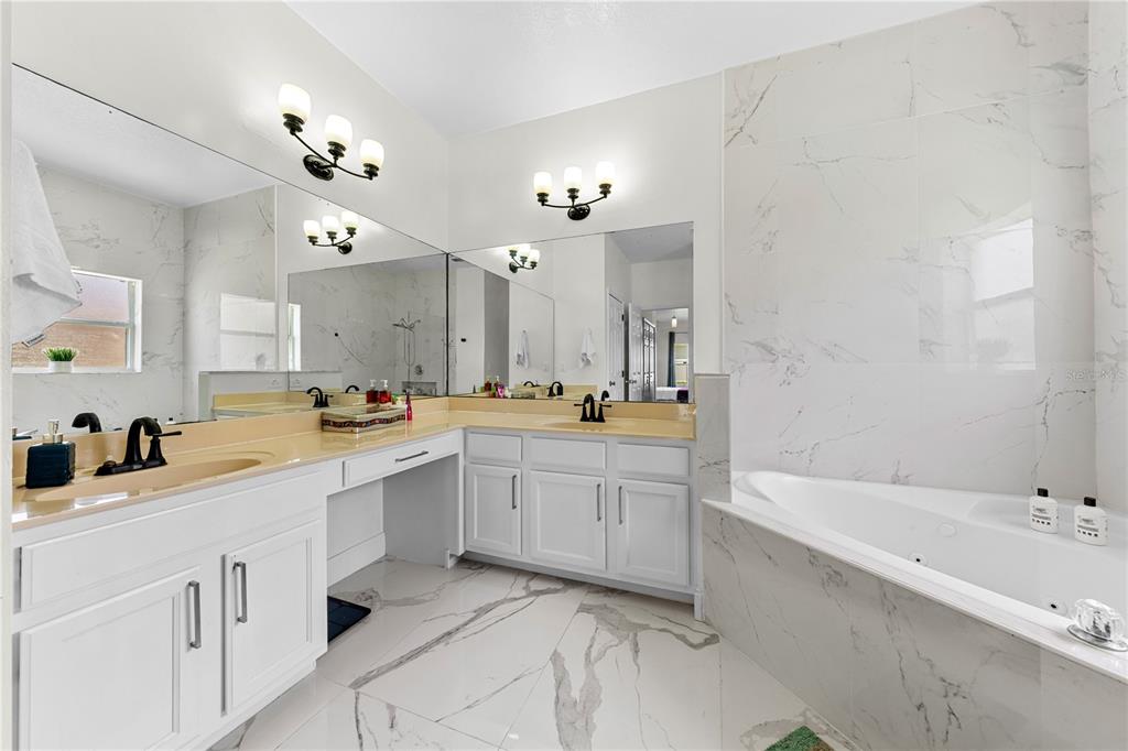 4301 Presidio Way Kissimmee, FL 34746 - Photo 22 of 50 a large white bathroom with a large tub sink vanity granite and a mirror