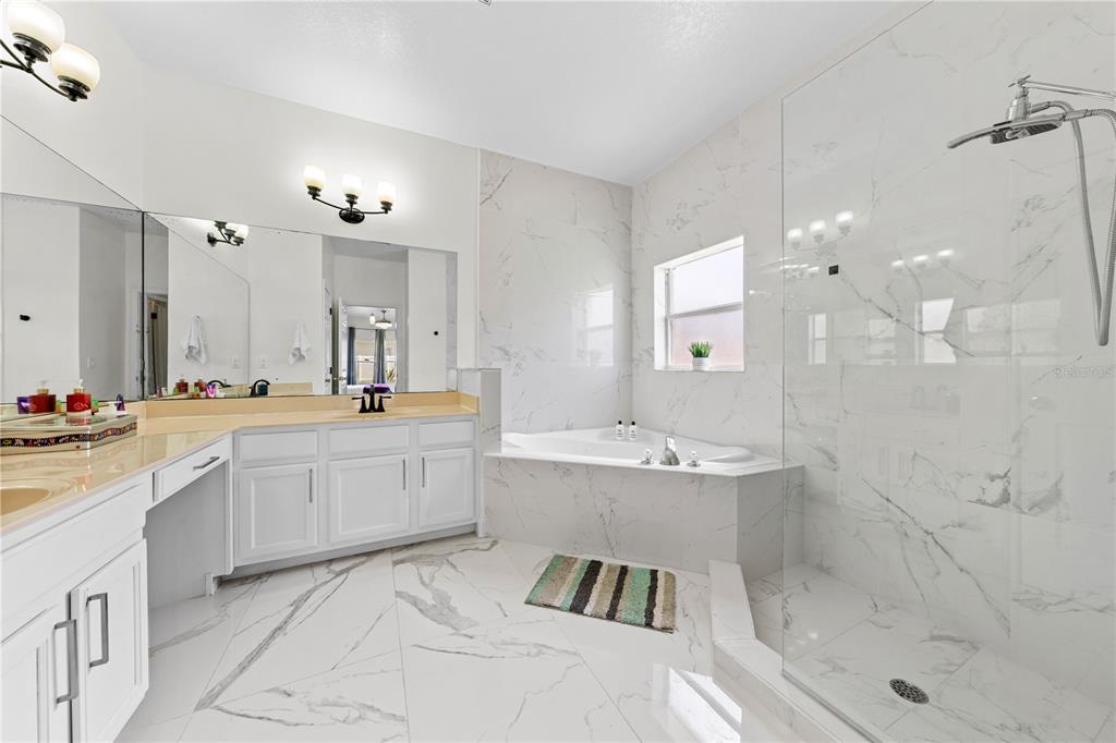 4301 Presidio Way Kissimmee, FL 34746 - Photo 24 of 50 a spacious bathroom with a bathtub shower sink and mirror