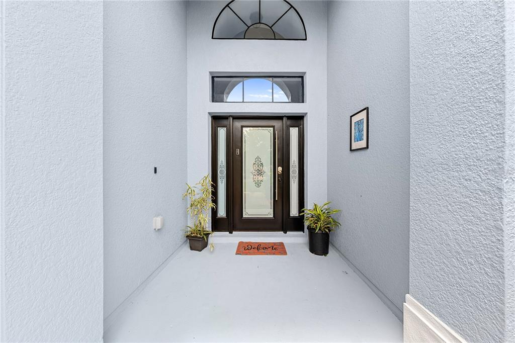 4301 Presidio Way Kissimmee, FL 34746 - Photo 3 of 50 a view of a hallway with wooden floor and a chandelier