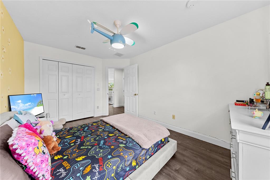 4301 Presidio Way Kissimmee, FL 34746 - Photo 32 of 50 a bedroom with bed and wooden floor