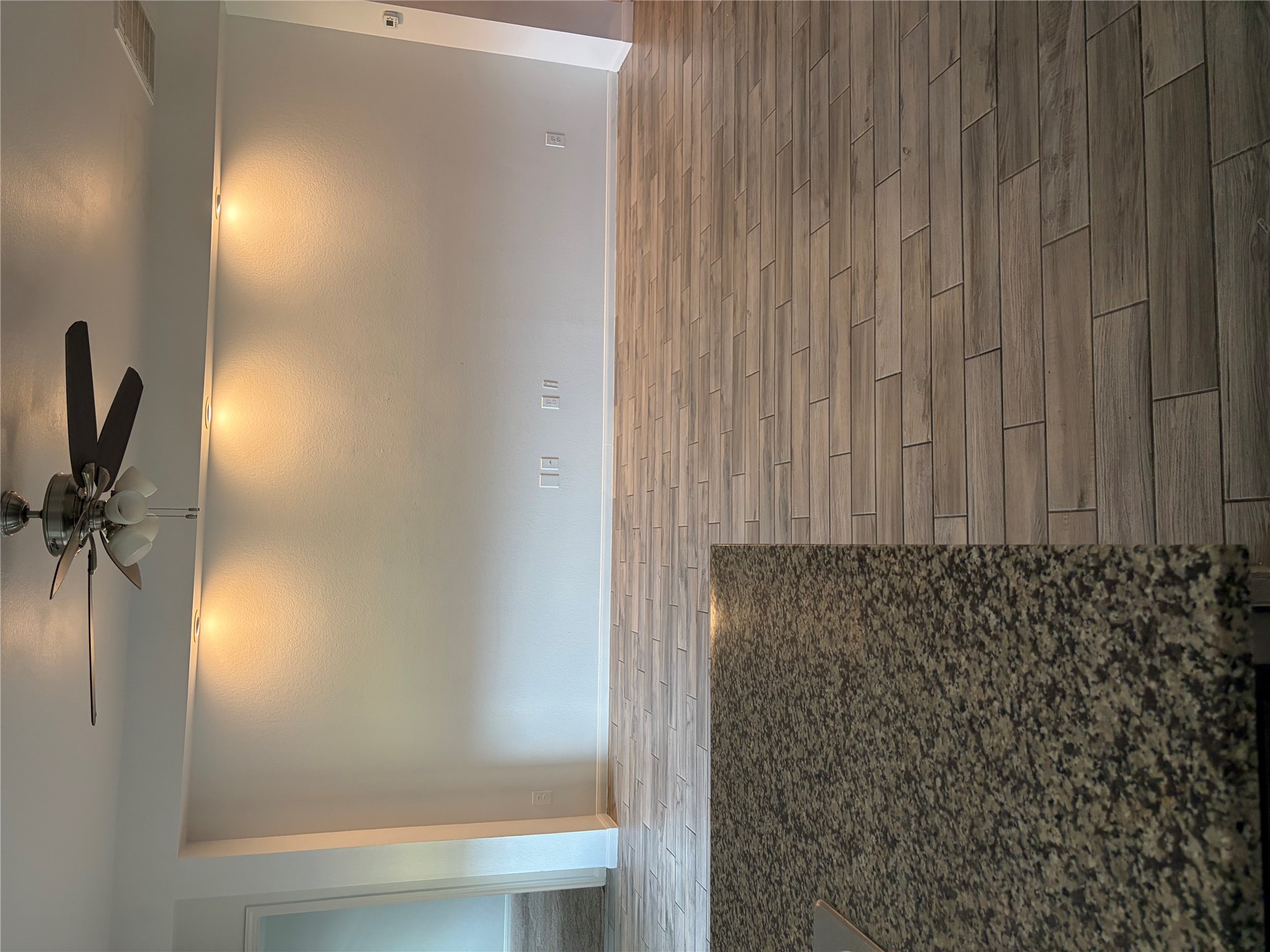 137 Rafe Court Kyle, TX 78640 - Photo 31 of 36 Granite counters complement the wood-look tile flooring in this contemporary open-concept living area.
