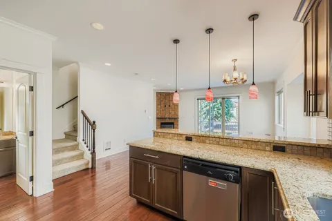 a kitchen that has a sink a window and wooden floor