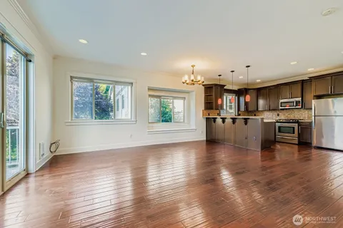 a view of a kitchen with wooden floor and a kitchen space