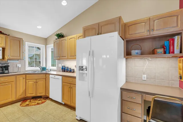 a kitchen with stainless steel appliances granite countertop a sink a refrigerator and cabinets